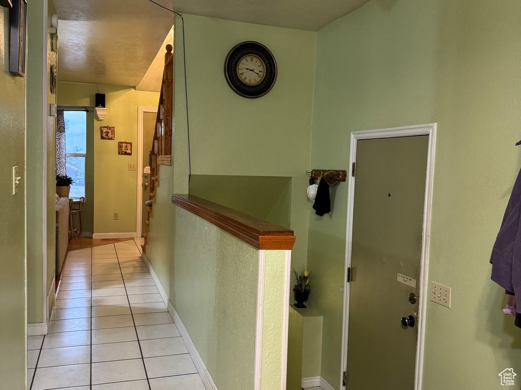 Corridor featuring light wood-type flooring, stairway, and baseboards