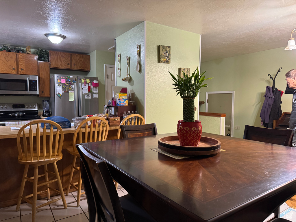 Dining space featuring a textured ceiling and light tile patterned flooring