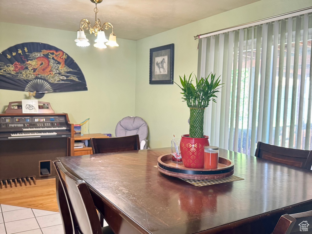 Dining space with a textured ceiling, a chandelier, and light tile patterned floors