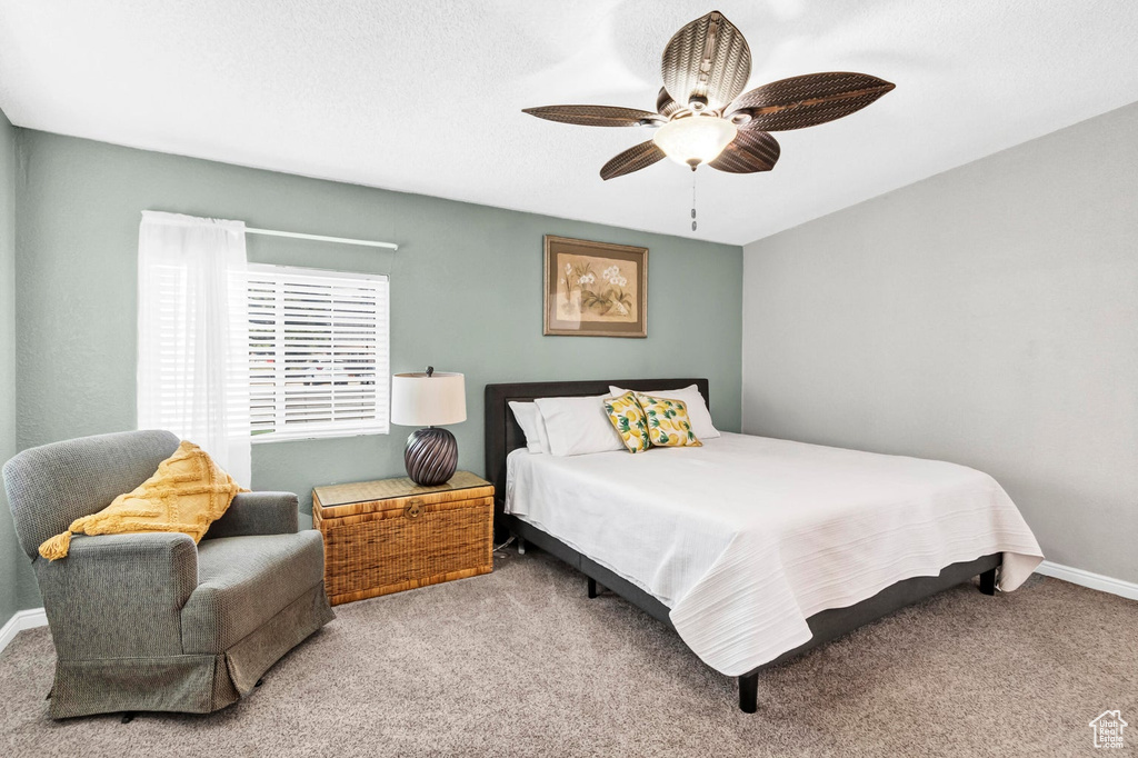 Carpeted bedroom with baseboards and a ceiling fan