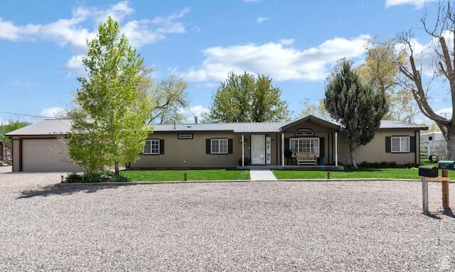 Ranch-style home with driveway, a front yard, and an attached garage