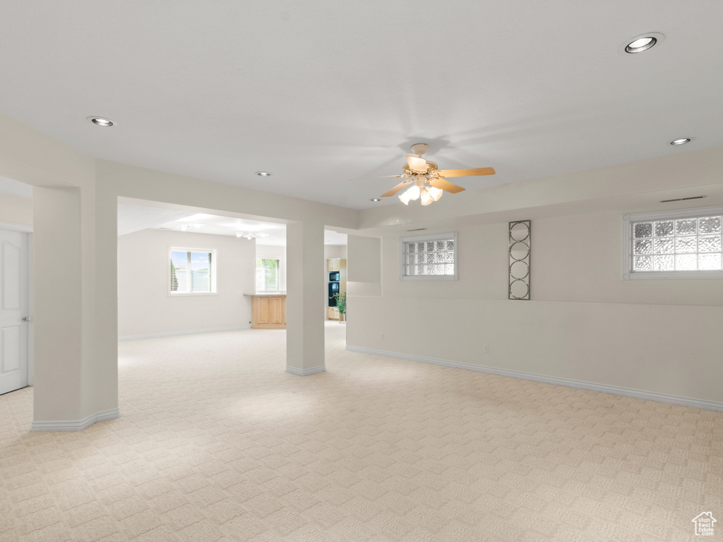 Interior space with ceiling fan, light carpet, and recessed lighting