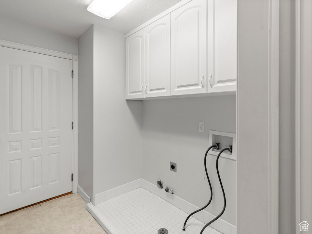Clothes washing area with cabinet space, hookup for an electric dryer, hookup for a gas dryer, washer hookup, and baseboards