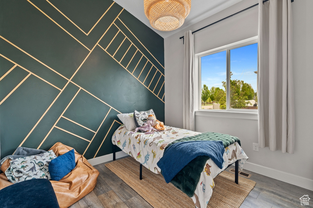 Bedroom with visible vents, wood finished floors, and baseboards