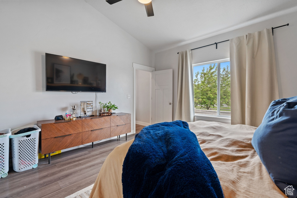 Bedroom with high vaulted ceiling, light wood-type flooring, and a ceiling fan
