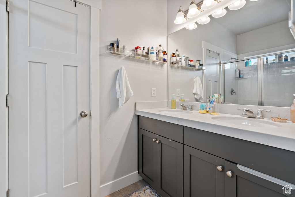Bathroom with a sink, double vanity, baseboards, and a shower stall