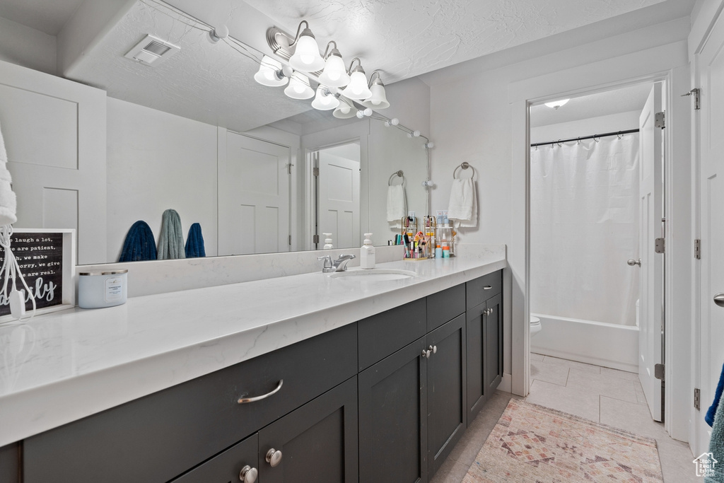 Bathroom featuring toilet, vanity, visible vents, shower / bath combo, and tile patterned flooring