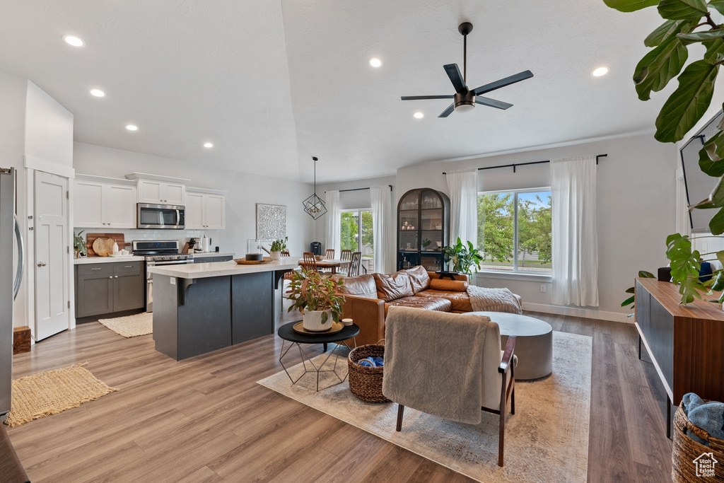 Living area with baseboards, recessed lighting, light wood-style floors, and ceiling fan