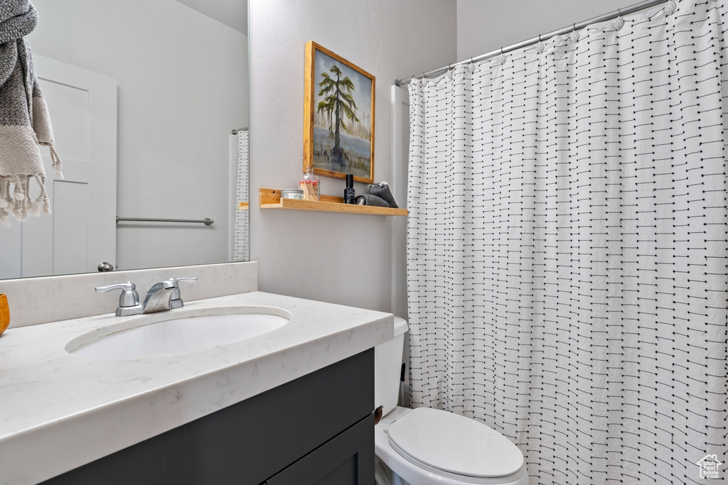 Bathroom with vanity, toilet, and a shower with shower curtain
