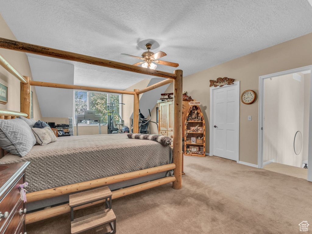 Carpeted bedroom with a textured ceiling and ceiling fan