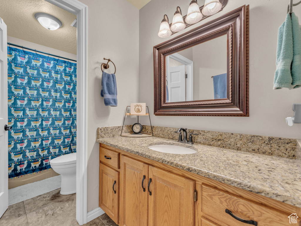 Bathroom featuring vanity, baseboards, and toilet