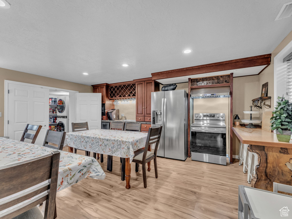 Dining area with light wood-style floors, recessed lighting, and visible vents