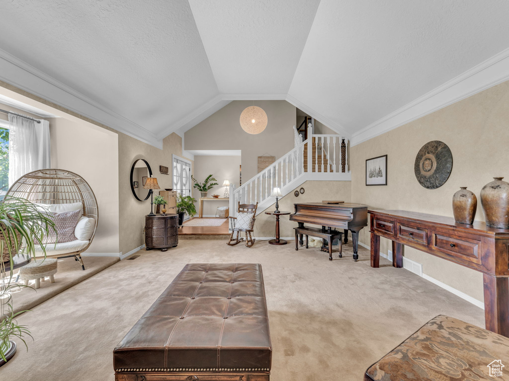 Carpeted living area featuring stairs, baseboards, vaulted ceiling, and crown molding