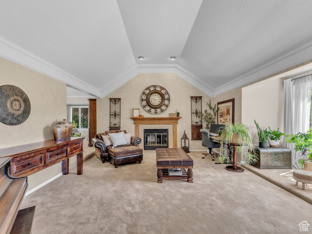 Living area with baseboards, carpet, vaulted ceiling, and a tile fireplace