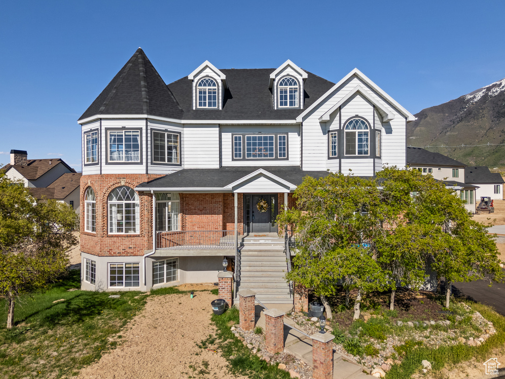 View of front facade featuring stairs and brick siding