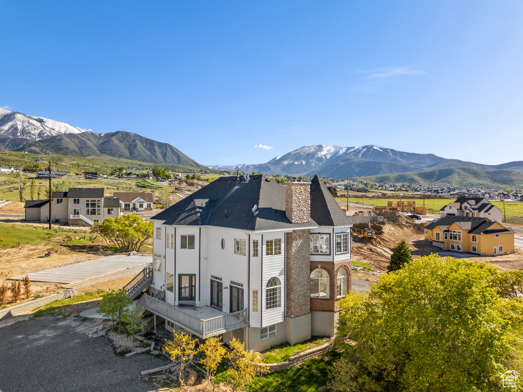 Exterior space featuring a mountain view, a chimney, and a balcony