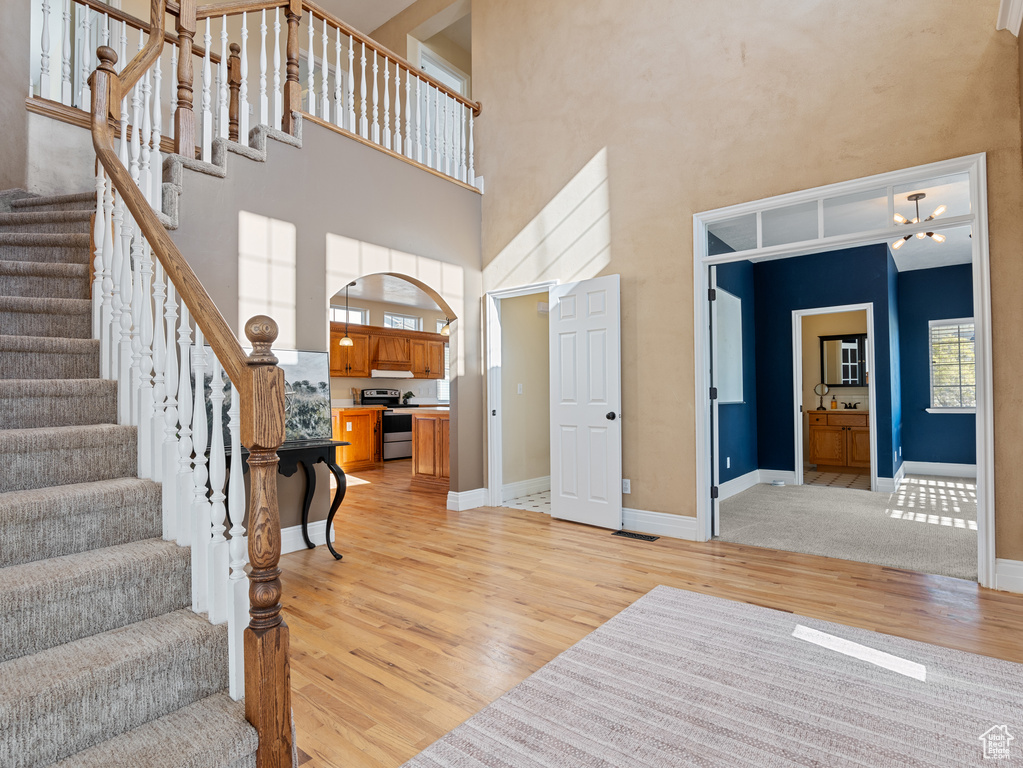 Entryway featuring stairs, light wood finished floors, and a high ceiling