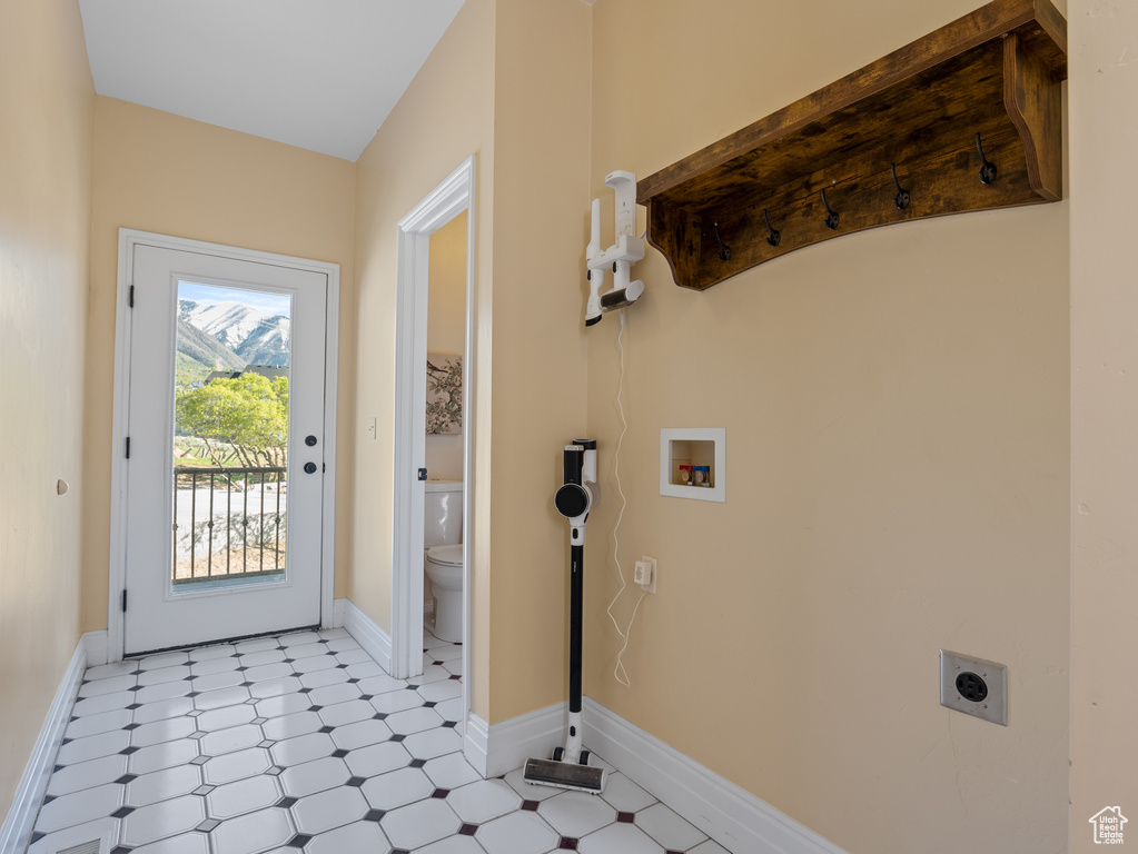 Doorway with light floors and baseboards