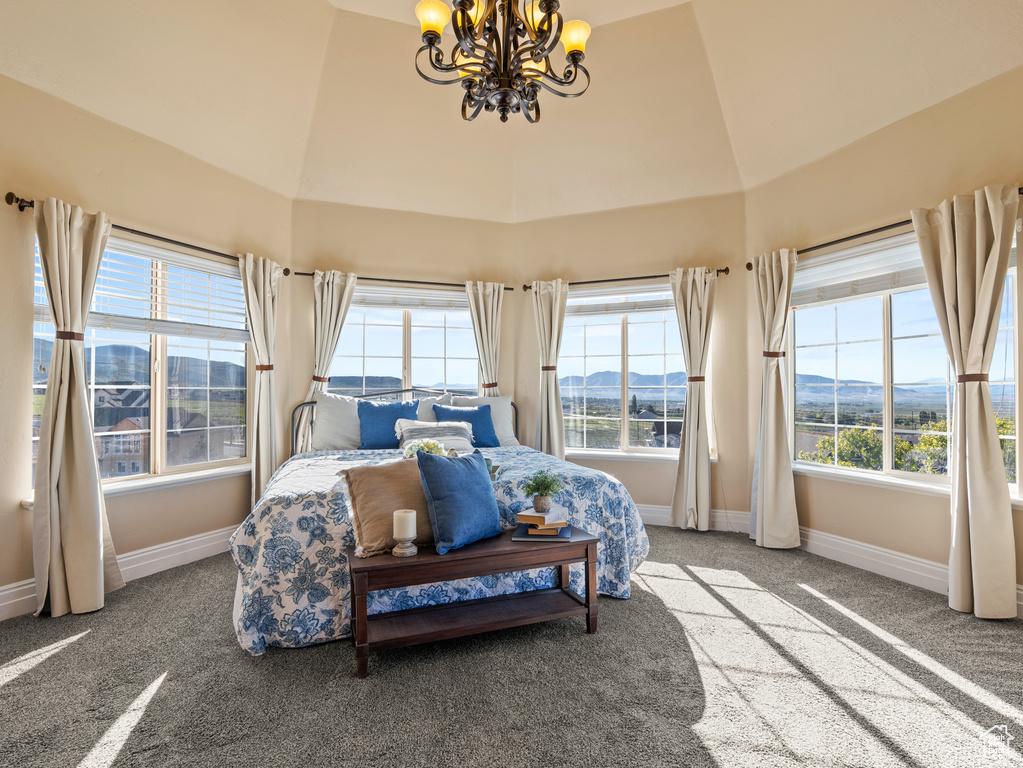 Bedroom with high vaulted ceiling, carpet floors, a notable chandelier, and baseboards