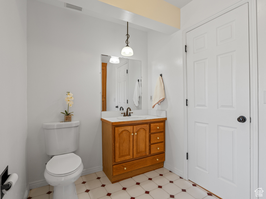 Bathroom featuring toilet, baseboards, visible vents, tile patterned floors, and vanity