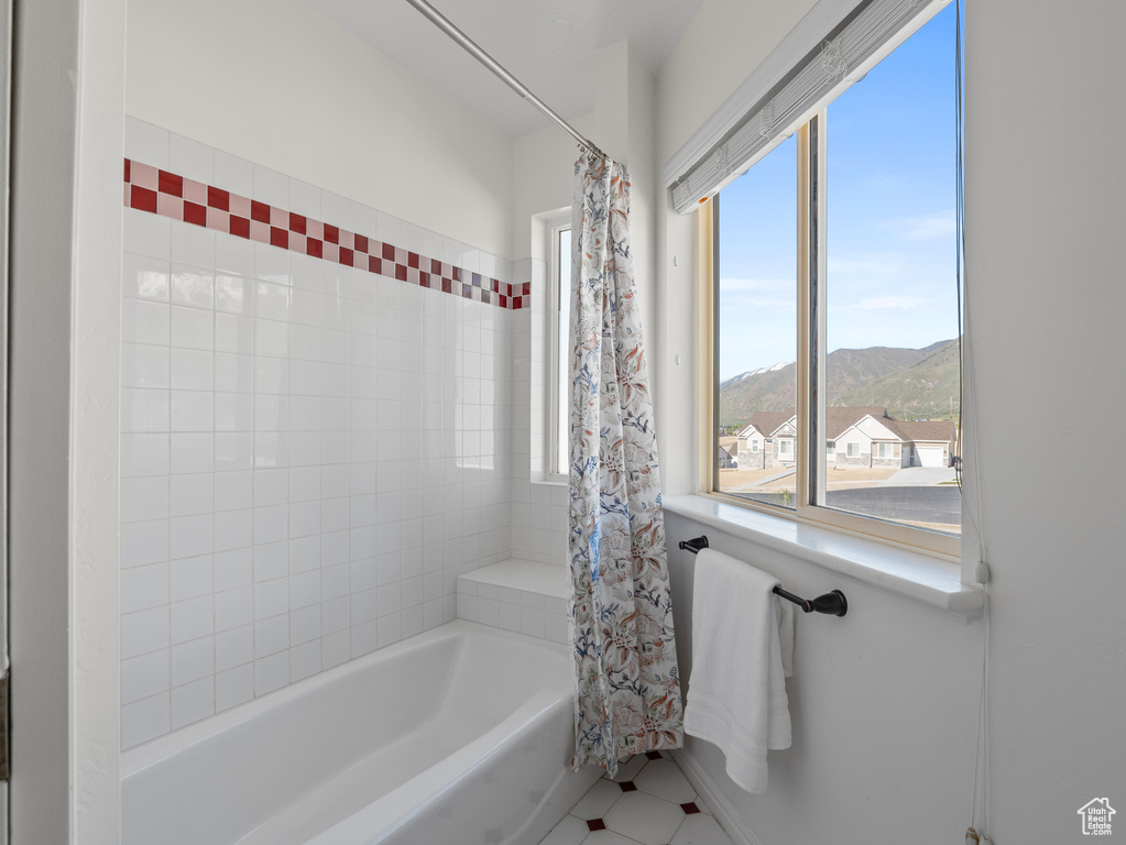 Full bath with a mountain view and shower / bath combo with shower curtain