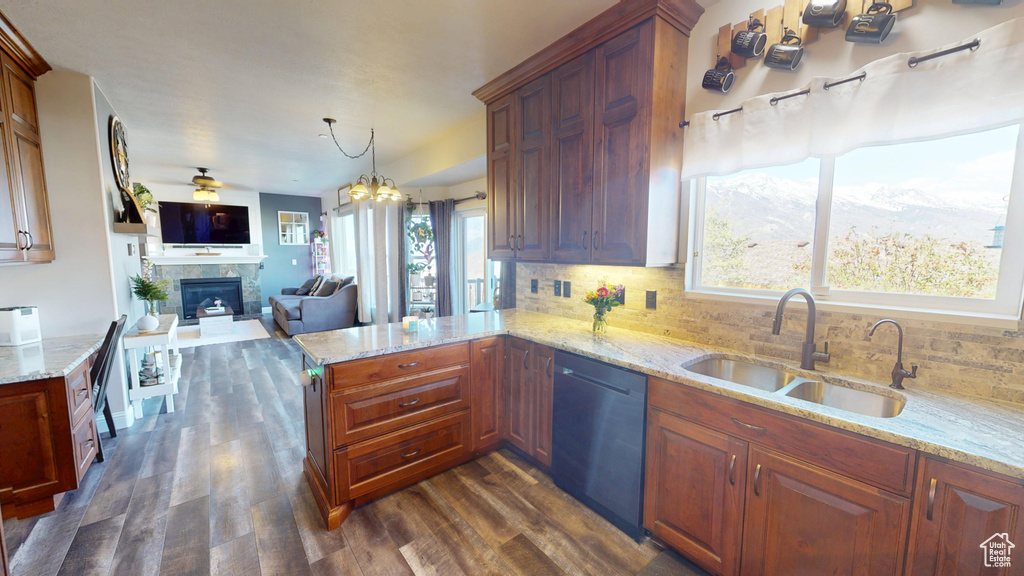Kitchen featuring a sink, a fireplace, dark wood finished floors, decorative backsplash, and dishwashing machine