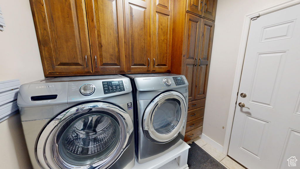 Washroom featuring washer and dryer and cabinet space