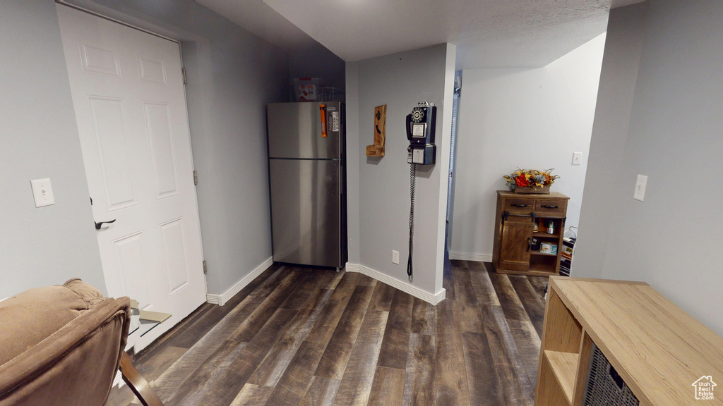 Hall featuring baseboards and dark wood-style flooring