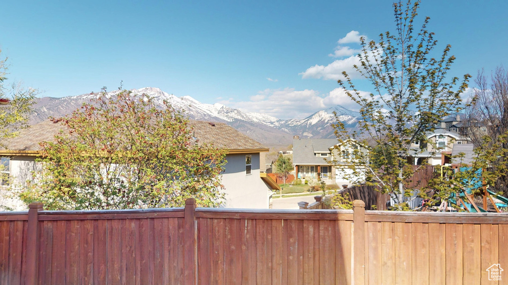 Exterior space featuring fence, a mountain view, and stucco siding