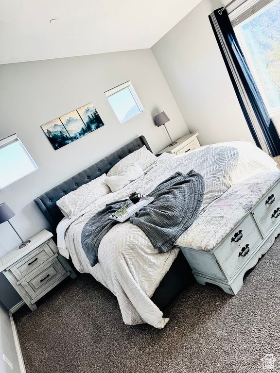 Bedroom with carpet floors and vaulted ceiling