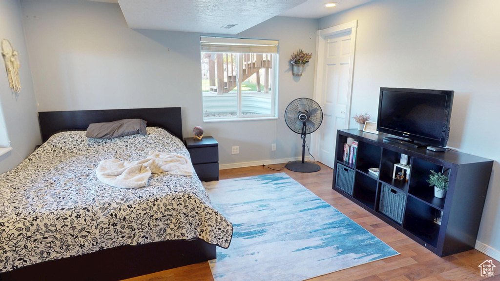 Bedroom with baseboards, wood finished floors, and visible vents