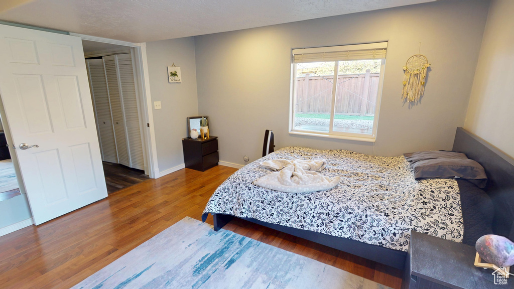 Bedroom with baseboards, a closet, and wood finished floors