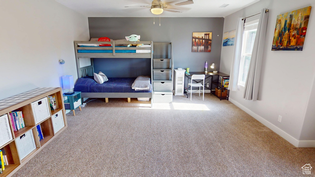 Carpeted bedroom with baseboards and ceiling fan