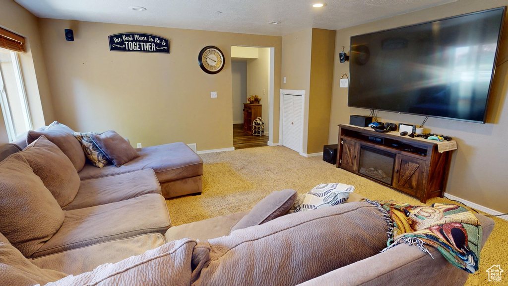 Carpeted living room with baseboards and recessed lighting