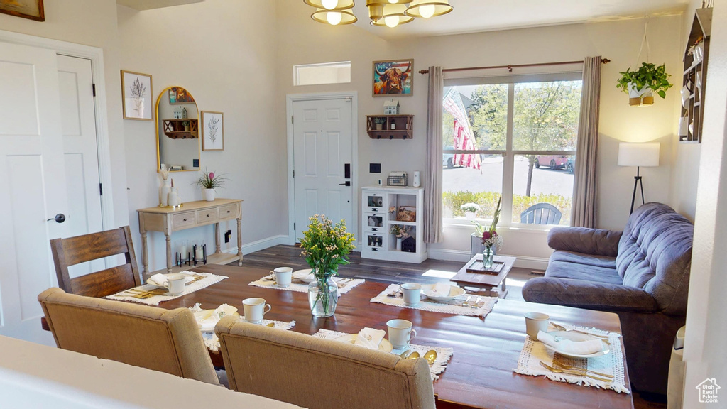 Living area with baseboards, a chandelier, wood finished floors, and lofted ceiling