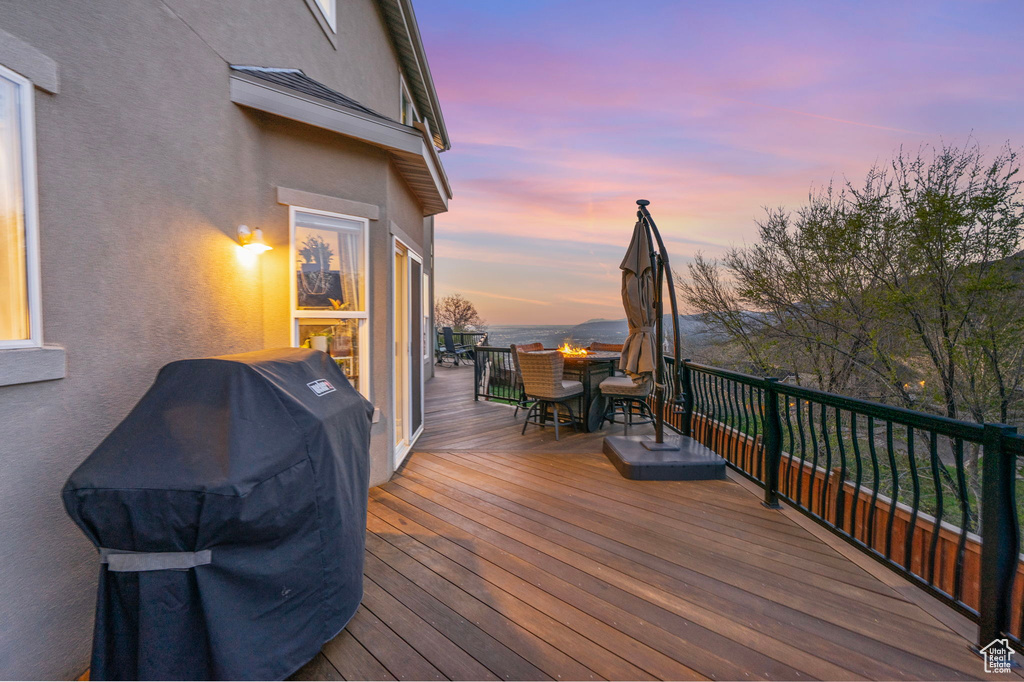 Wooden terrace featuring area for grilling and outdoor dining area