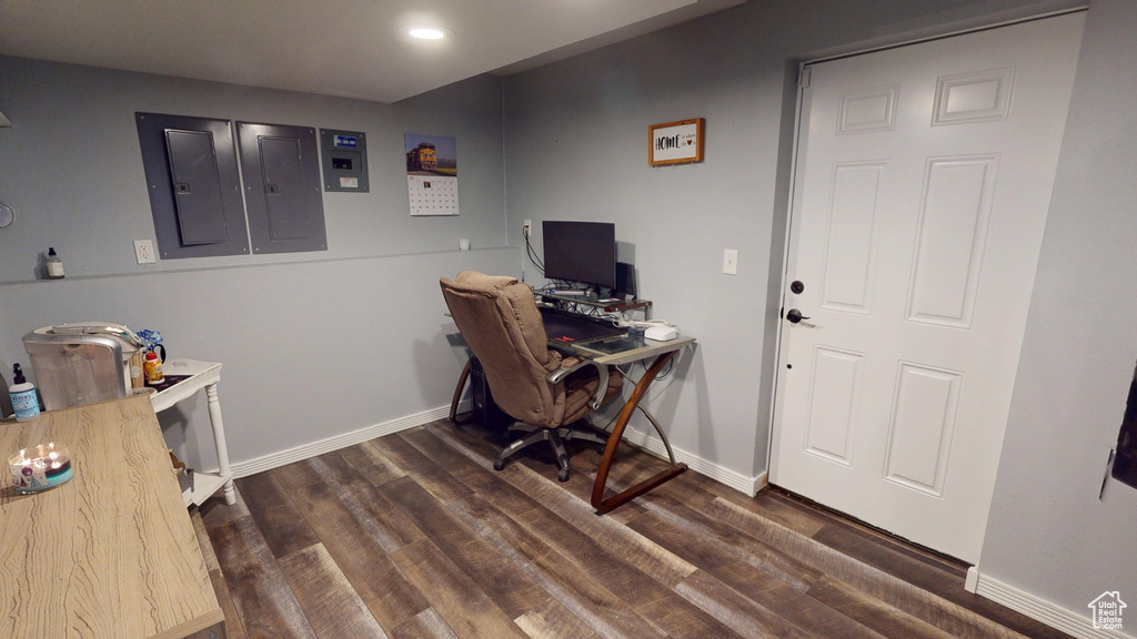 Office with baseboards, dark wood-type flooring, and electric panel