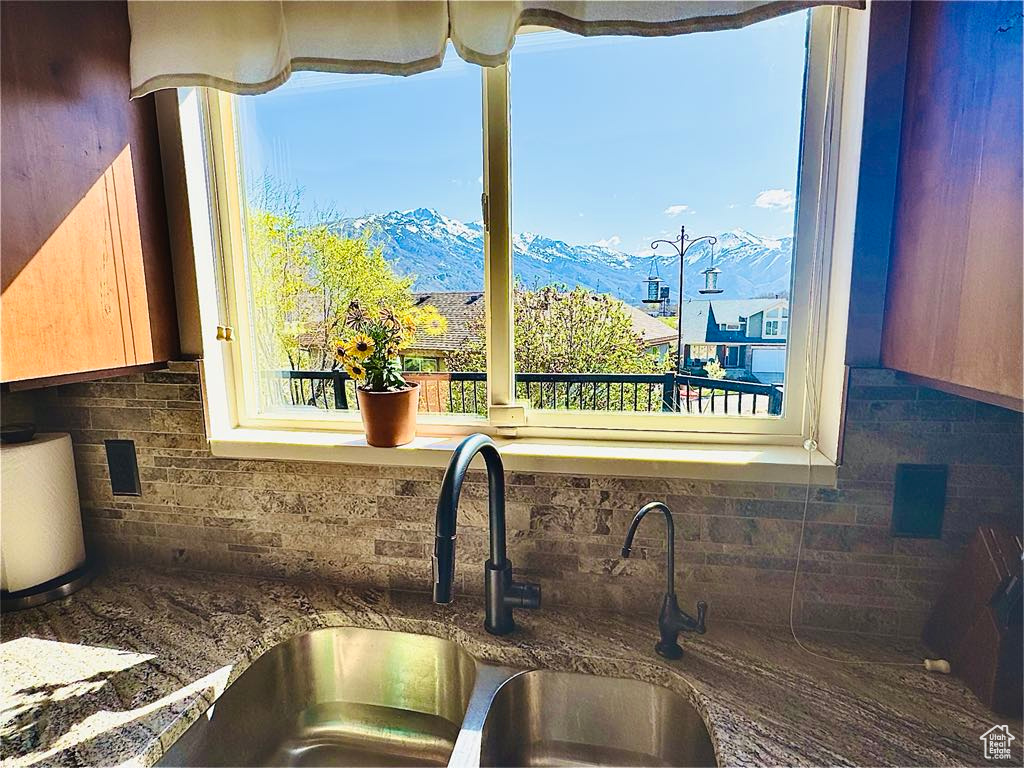 Details featuring a mountain view, a sink, and tasteful backsplash