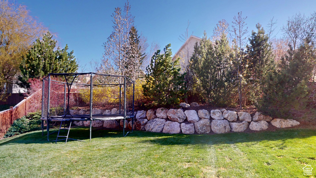 View of yard with fence and a trampoline