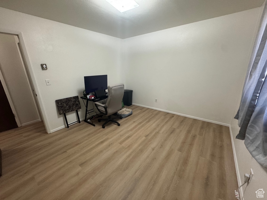 Home office with light wood-style floors and baseboards