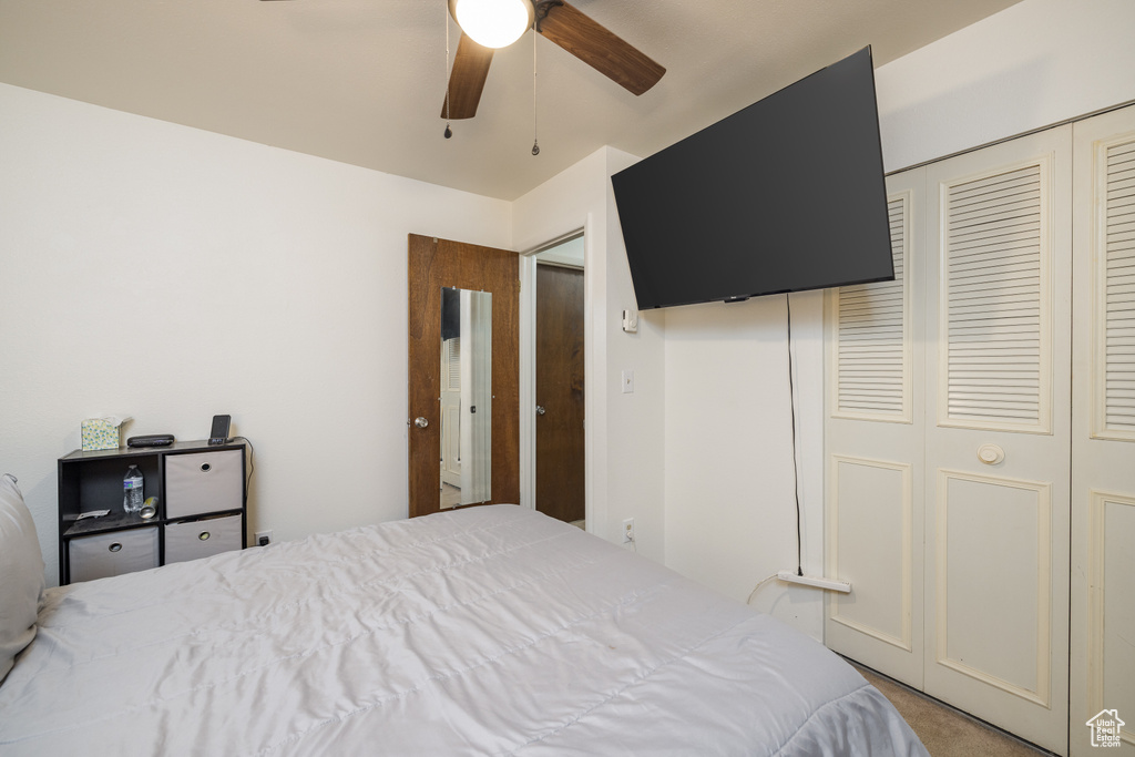 Bedroom with a closet, carpet, and a ceiling fan