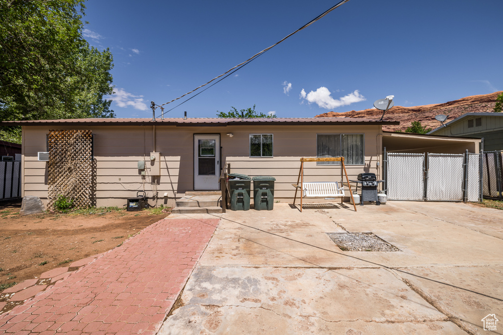 View of front facade with fence, a carport, and a gate