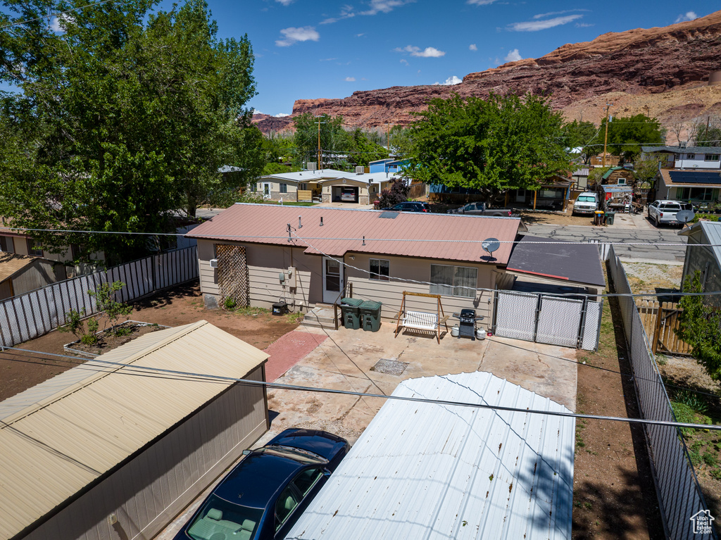 Back of property featuring a mountain view, metal roof, a fenced backyard, and a gate