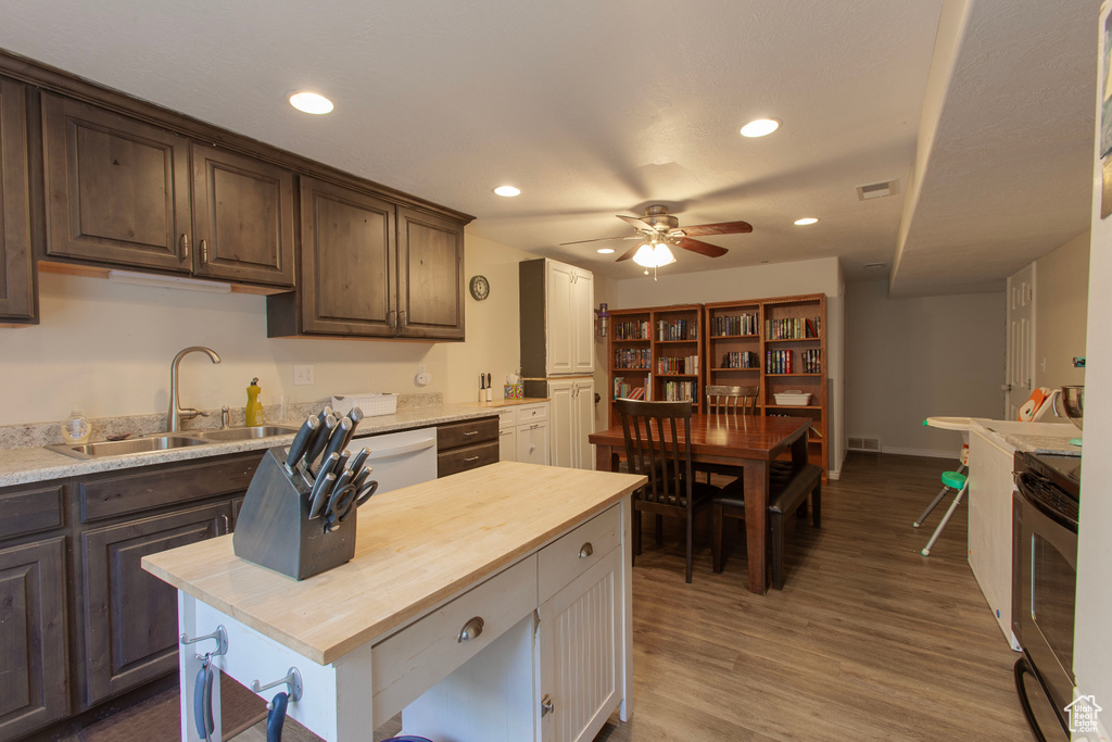 Kitchen featuring a sink, butcher block counters, recessed lighting, a ceiling fan, and stove
