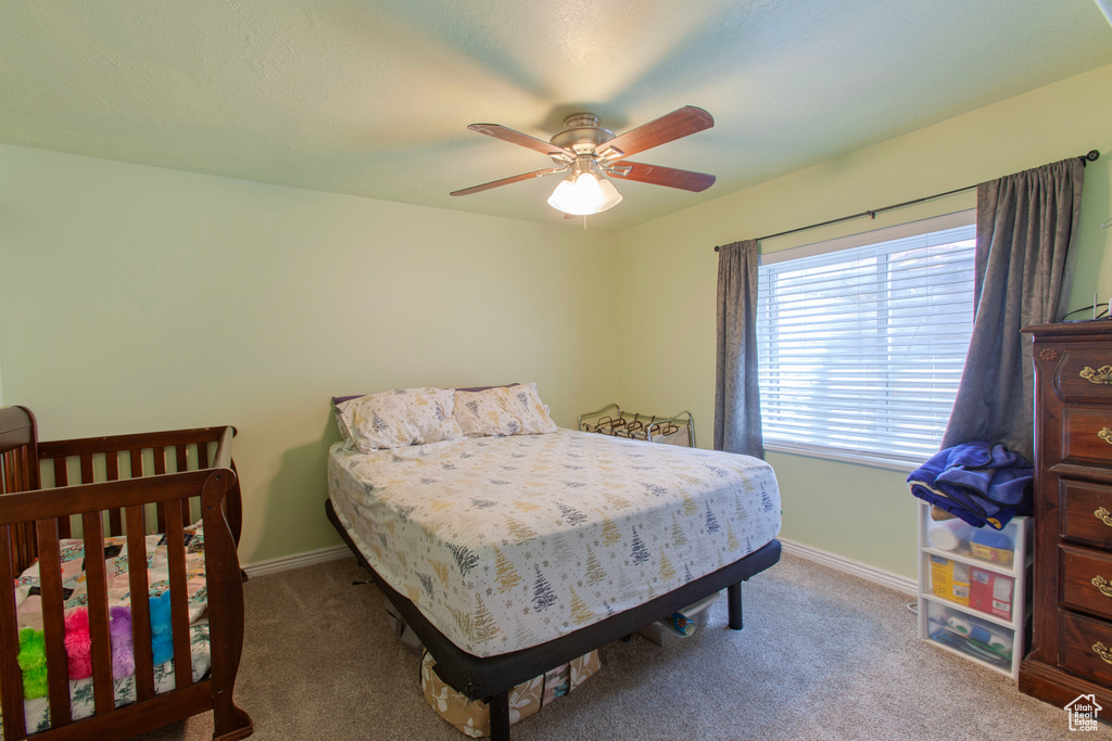 Carpeted bedroom with baseboards and a ceiling fan