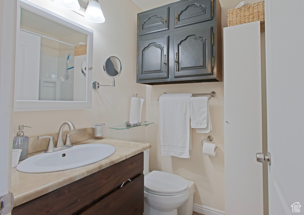 Bathroom with toilet, walk in shower, and vanity