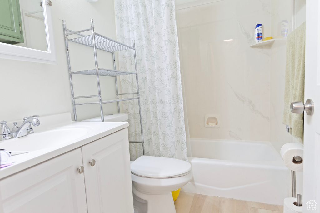 Bathroom with toilet, vanity, and shower / bathtub combination with curtain