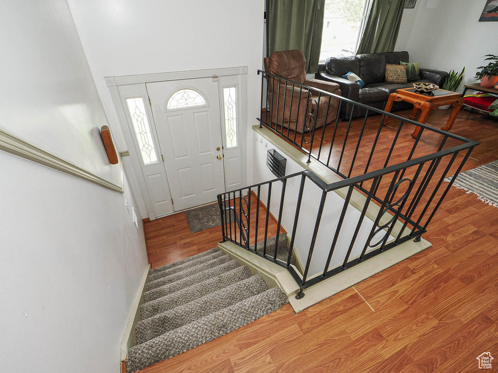 Entryway with wood finished floors, plenty of natural light, and stairway
