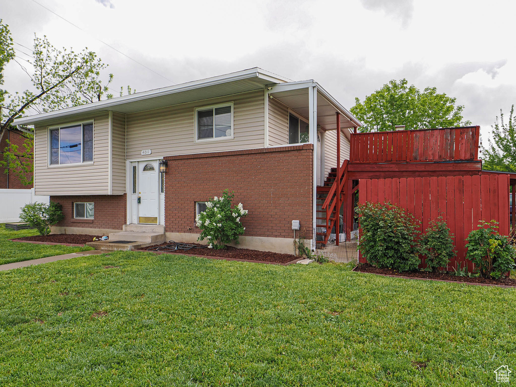 Split foyer home with a front lawn, stairs, entry steps, and brick siding