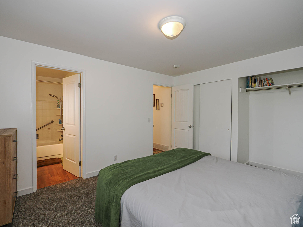 Bedroom with carpet floors, ensuite bath, and baseboards